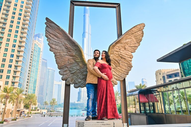 With magnificent wings in the background Maternity Photoshoot