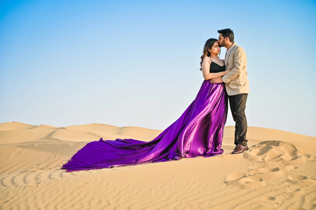 Pre wedding photography in Dubai featuring a couple in a romantic desert photoshoot with a flowing purple dress