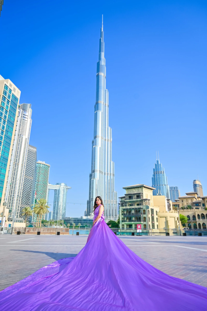 Pre wedding photography in Dubai featuring a bride in a flowing purple dress with Burj Khalifa in the background